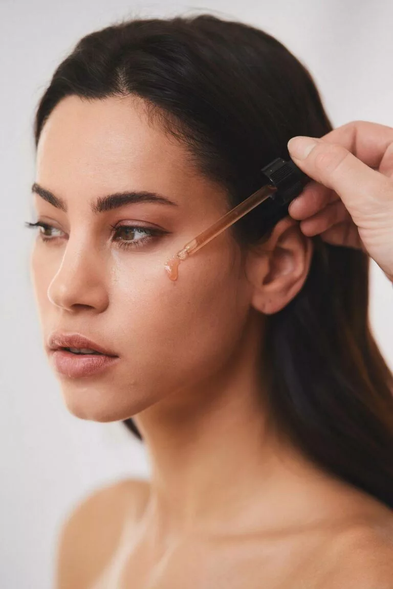 Application d’un sérum détox sur le visage d’une femme pour revitaliser la peau après les fêtes - Maelis Centre Laser