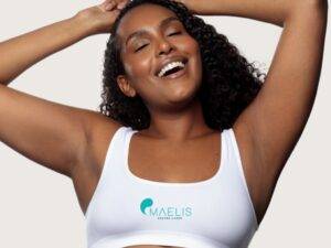 Femme à la peau foncée ou noire ayant les bras levée laissons apparaître ses aisselles parfaitement épilée au laser définitif chez Maelis