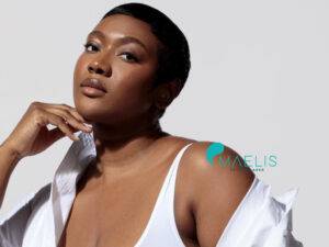 Femme noire portant une chemise blanche ainsi qu'un top blanc dans un centre laser Maelis