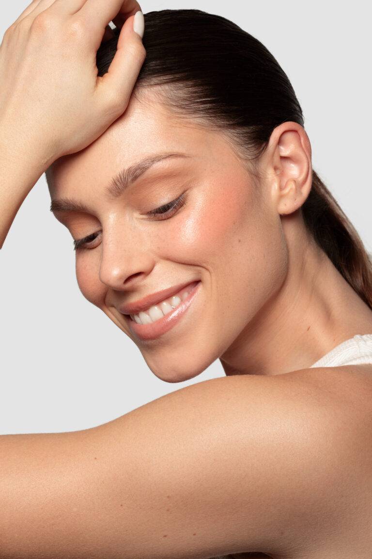 Femme à la peau rayonnante qui sourit après avoir réalisée un soin Hydrafacial adapté chez Maelis